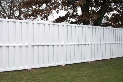 A white fence encloses a yard in Batavia, IL, highlighting the charm of the residential area