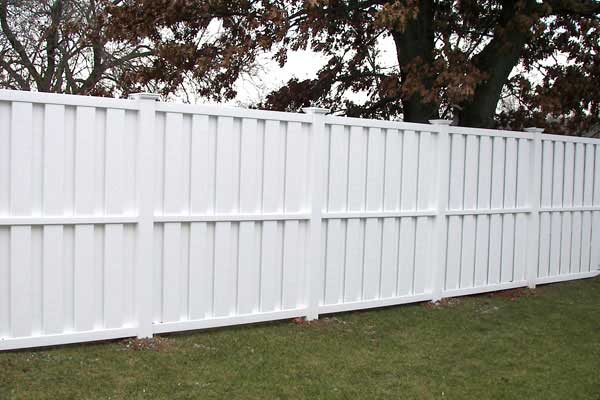 A white fence encloses a yard in Batavia, IL, highlighting the charm of the residential area
