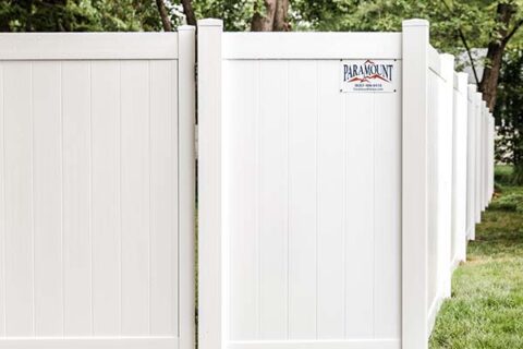 A white fence featuring a sign attached to it in Batavia, IL