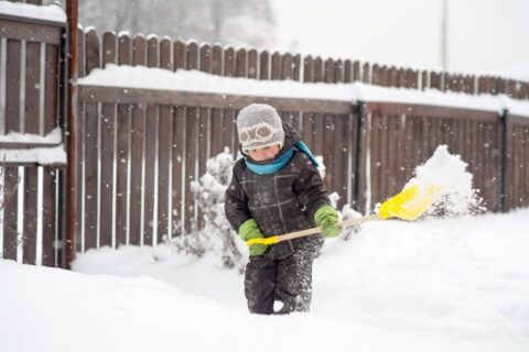 The kid shoveling snow by Paramount Fence
