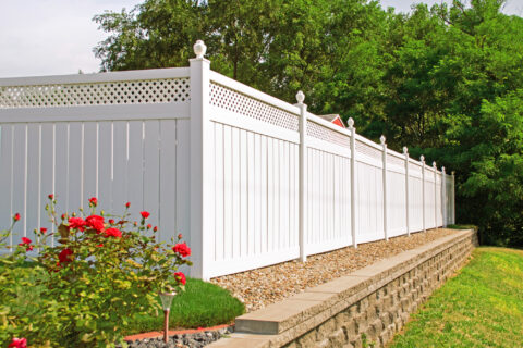 White fence and stone wall with blooming flowers, captured in Batavia, IL