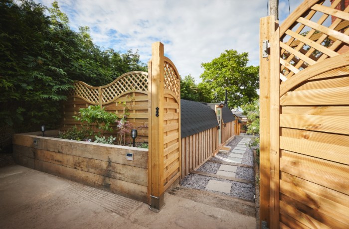 Backyard garden fence and walkway at home in summer, surrounded by trees and landscape in Chicagoland, IL