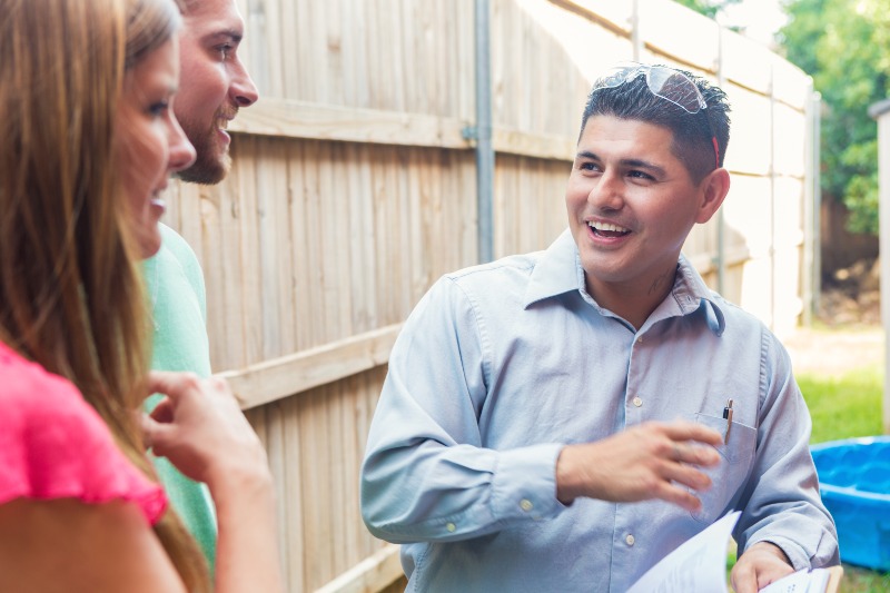 Repairman giving homeowners estimate for costs of fence installation in Chicagoland, IL