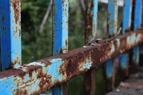 Close-up of rusting blue metal fence in Chicagoland Suburbs, IL