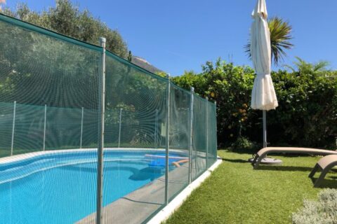 Swimming pool with mesh safety fence in backyard in Chicago, IL