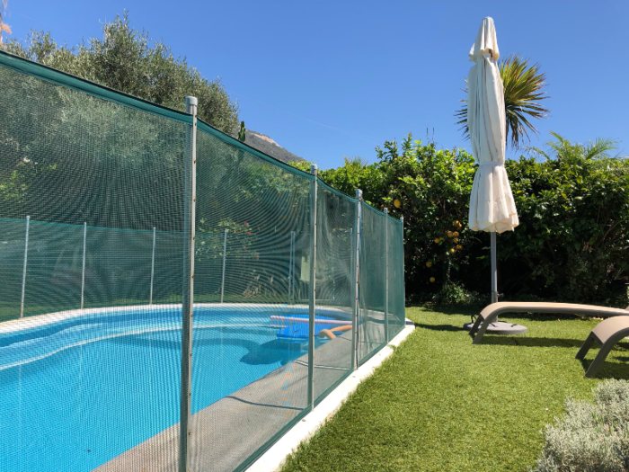 Swimming pool with mesh safety fence in backyard in Chicago, IL