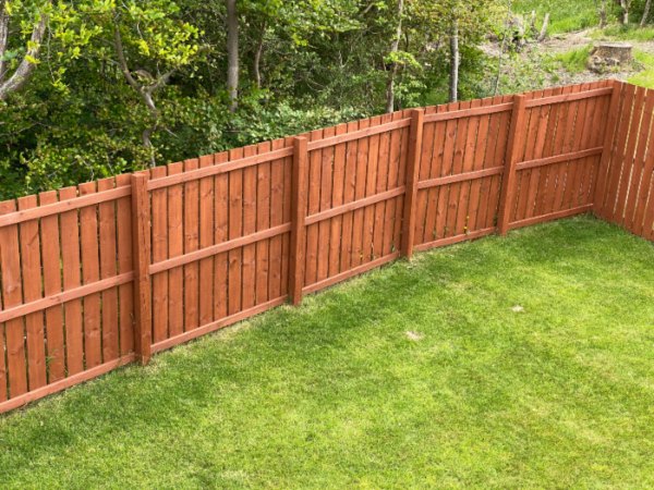 Wooden garden fence coated with medium oak stain in Chicago, IL
